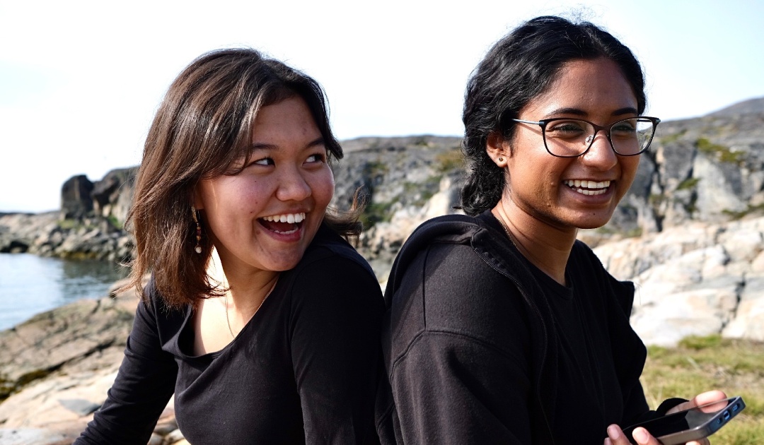 Zwei der Arctic Resilient Comunities Youth Fellows genießen eine Pause am Strand von Sisimiut, Grönland. Foto: ARCYF 